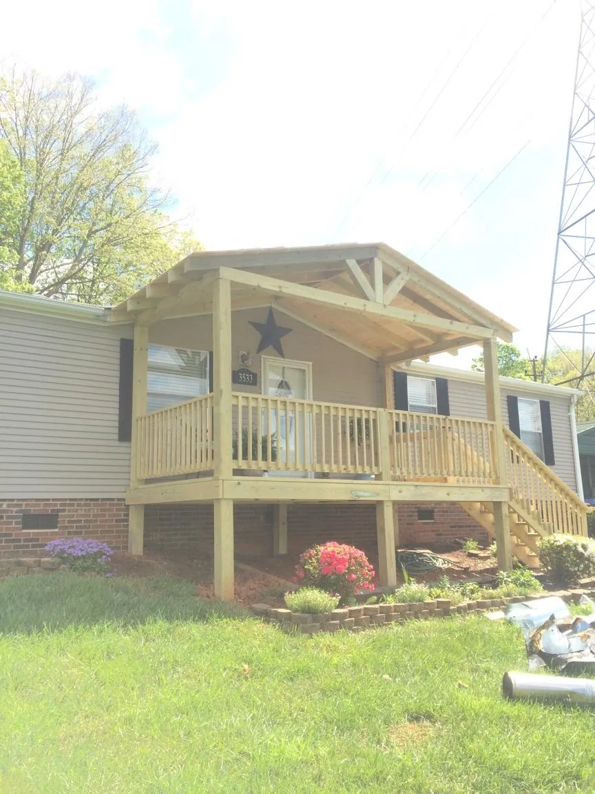 New gabled porch roof and deck railing added to a ranch home in Brownville
